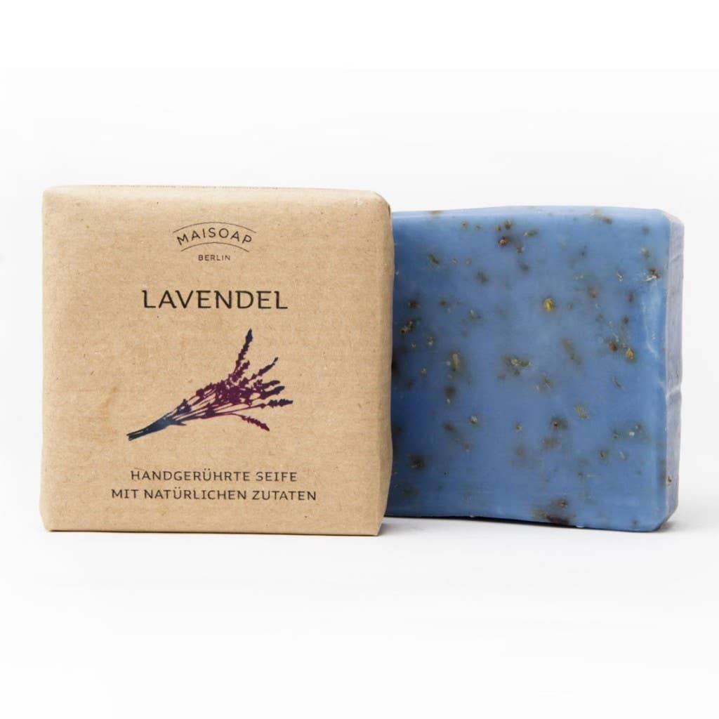 Ein Riegel Maisoap | Lavendel Seife mit Pflanzenteilen liegt in der braunen Maisoap-Papierverpackung, beschriftet mit "Lavendel" und einer Lavendelabbildung - perfekt für ein entspanntes Duscherlebnis und klassische Hautpflege.