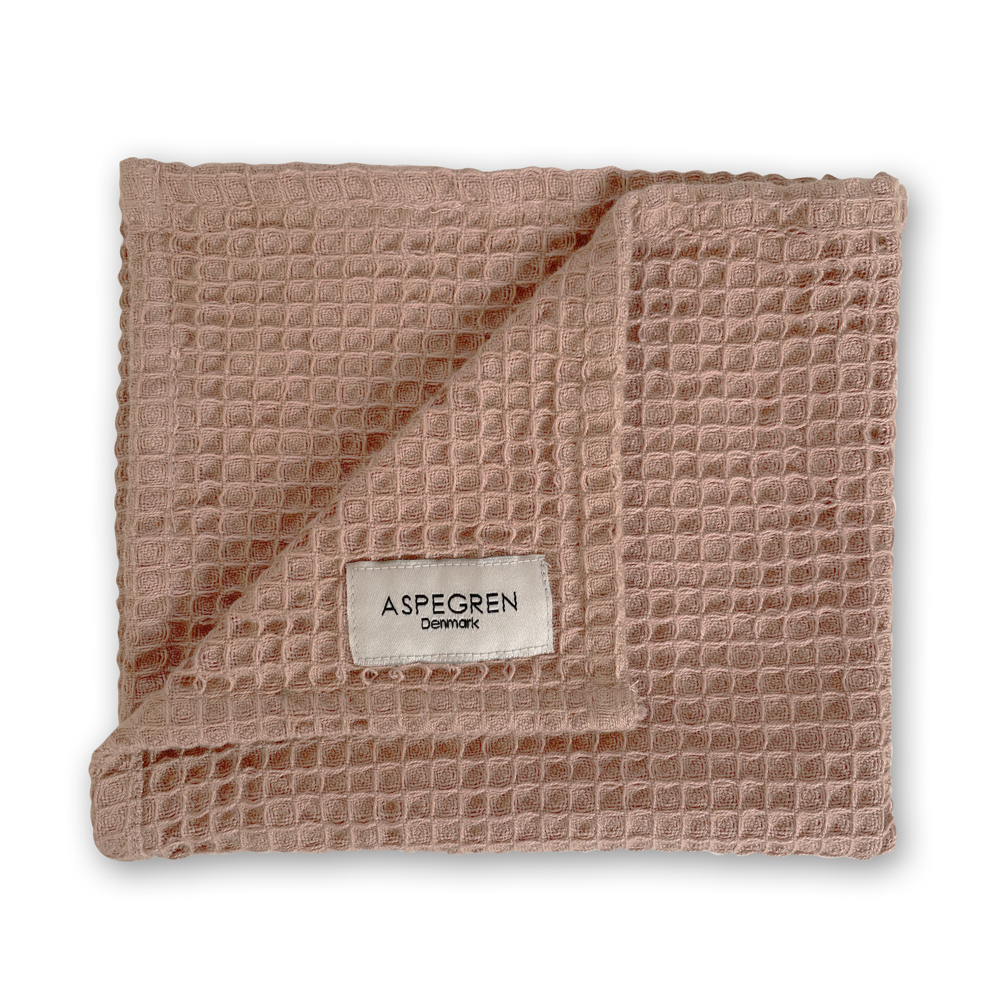 Ein gefaltetes, rosa Küchentuch mit Waffelmuster aus dem „Aspegren Denmark Küchentuch 3er Geschenkset in warmen Rosatönen“ ist abgebildet, wobei eine Ecke umgeschlagen ist und ein weißes Etikett mit der Aufschrift „Aspegren Denmark“ vor einem schlichten weißen Hintergrund sichtbar wird.