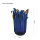 Die mittelgroße Vase „Giusy“ der Serie „Murano Dream“ aus blauem Murano-Glas (H 24 cm, Ø 19 cm) besticht durch elegante, gewellte Ränder und exklusive italienische Glaskunst vor weißem Hintergrund mit Maßlinien.