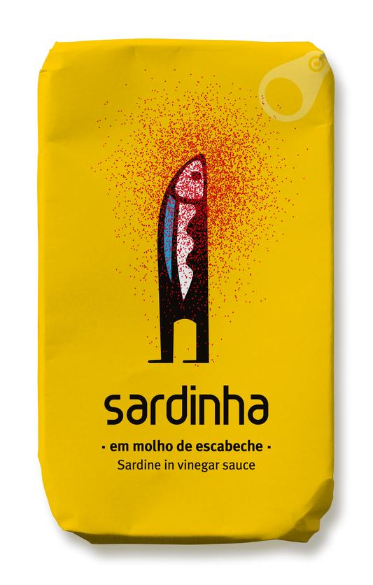 Eine gelbe Blechdose der Marke Sardinha ziert eine minimalistische Darstellung eines schwarzen Fisches mit roten Flecken. Der Text lautet „Sardinha em molho de escabeche“, „Sardine in Essigmarinade“ und „Sardinen in Escabeche“. Das Produkt wird als reich an Eiweiß und Omega-3-Fettsäuren ausgewiesen; die Aufreißlasche ist in der oberen rechten Ecke zu sehen. Der Produktname lautet Sardinha | Sardine in Essigmarinade.