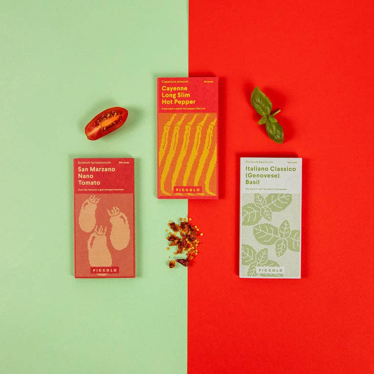 Drei leuchtende Päckchen Piccolo Seeds | Tomatensoße von Piccolo Seeds sind auf grünem und rotem Hintergrund abgebildet, daneben sind frische Basilikumblätter, eine halbierte Tomate und Paprikaflocken kunstvoll angeordnet.