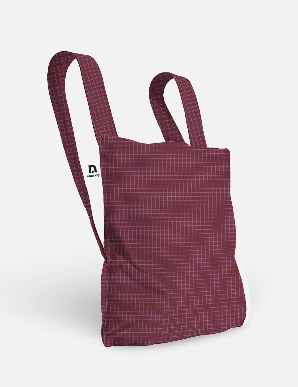 Selbstverständlich! Hier ist eine überarbeitete Version des Satzes unter Verwendung der angegebenen Produktdaten: A Notabag | Wandelbare Tasche und Rucksack „Pflaume“ von Notabag mit rotem Design und blauen Gitterlinien, zwei Tragegriffen und einem kleinen weißen Etikett mit dem schwarzen Notabag-Logo. Der Hintergrund ist schlicht weiß.