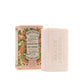 Ein Stück Panier Des Sens | Duftseife Rosengeranie 150 g liegt neben seiner dekorativen Schachtel mit orangefarbenen und grünen botanischen Motiven und dem Text "Savon Parfumé Floral Elixir". Die Seife ist mit der Marke Panier Des Sens geprägt.