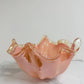 Die Murano Dream Dekoschale „Fazzoletto“ aus rosa Murano-Glas (H 20, Ø 22 cm) mit glänzender Oberfläche steht auf weißem Marmor vor einem hellen Hintergrund.
