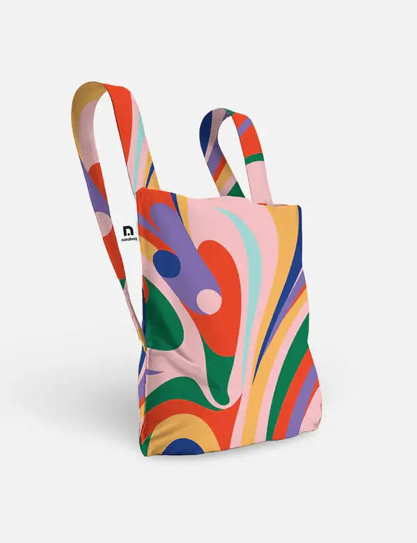 Die Notabag | 'Flow' Kombination aus Tasche & Rucksack von Notabag zeichnet sich durch lange Griffe und ein leuchtendes abstraktes Wirbelmotiv in Rot, Grün, Blau, Gelb, Pink und Lila aus - eine Kombination aus stylischem Design und umweltfreundlicher Nachhaltigkeit.