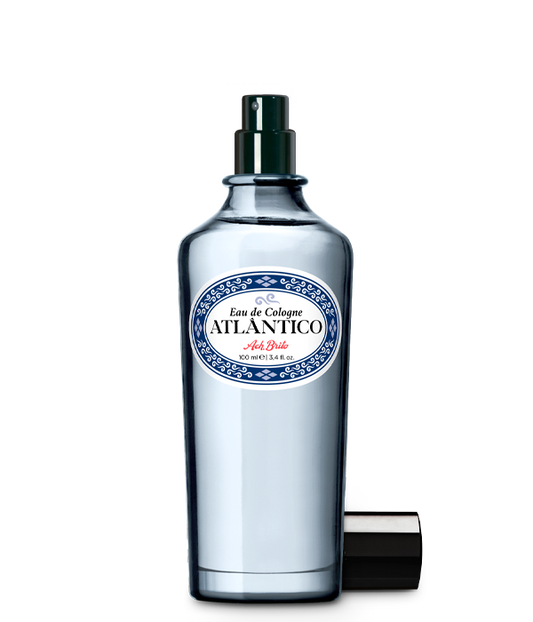 Der klare Glasflakon mit der Aufschrift Eau de Cologne | Atlântico 100 ml von Ach.Brito in blau-weißem Design mit dunklem Sprühkopf und passender Kappe erinnert an die Meeresfrische des klassischen Atlântico-Duftes.