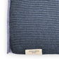 Eine Nahaufnahme eines strukturierten, tiefblauen Strickstoffs in nordischem Blau aus Bio-Baumwolle, mit einem hellgrauen Rand und einem kleinen beigen Etikett mit der Aufschrift „ASPEGREN Denmark“ am unteren Rand – ein elegantes Beispiel für Küchentextilien aus dem „Aspegren Denmark Premium 3er Küchentuchset“.