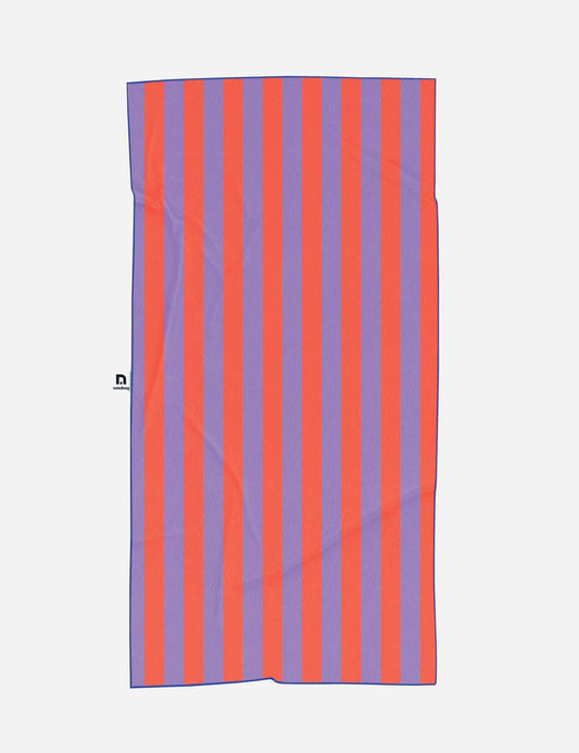 Das „Notabag | Handtuch rot & lila gestreift 78 × 160 cm“ ist ein rechteckiges Handtuch mit vertikalen roten und violetten Streifen, das von Notabag aus recyceltem Material hergestellt wurde. Auf der linken Seite befindet sich ein kleines schwarz-weißes Etikett.