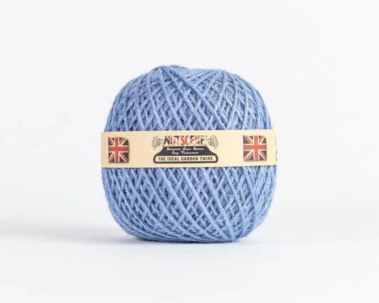 Ein Knäuel „Nutscene | Heritage Jutegarn“ in der Farbe „Bluebell“ (130 m) von Nutscene Twines Ltd mit einem beigen Etikett, auf dem der Markenname „Nutscene“, zwei Union-Jack-Flaggen und der Schriftzug „The Ideal Garden Twine“ vor einem schlichten weißen Hintergrund abgebildet sind.