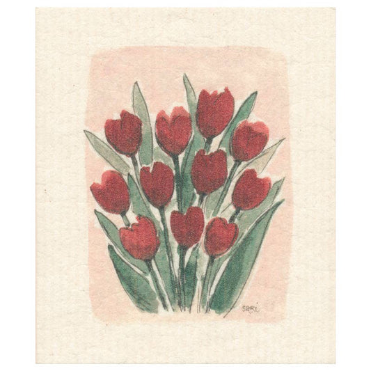 Ein handgemalter Strauß roter Tulpen mit grünen Blättern ziert das beigefarbene 'Rote Tulpen' biologisch abbaubares Schwammtuch von More Joy Home, das in der rechten unteren Ecke Saris Unterschrift trägt.