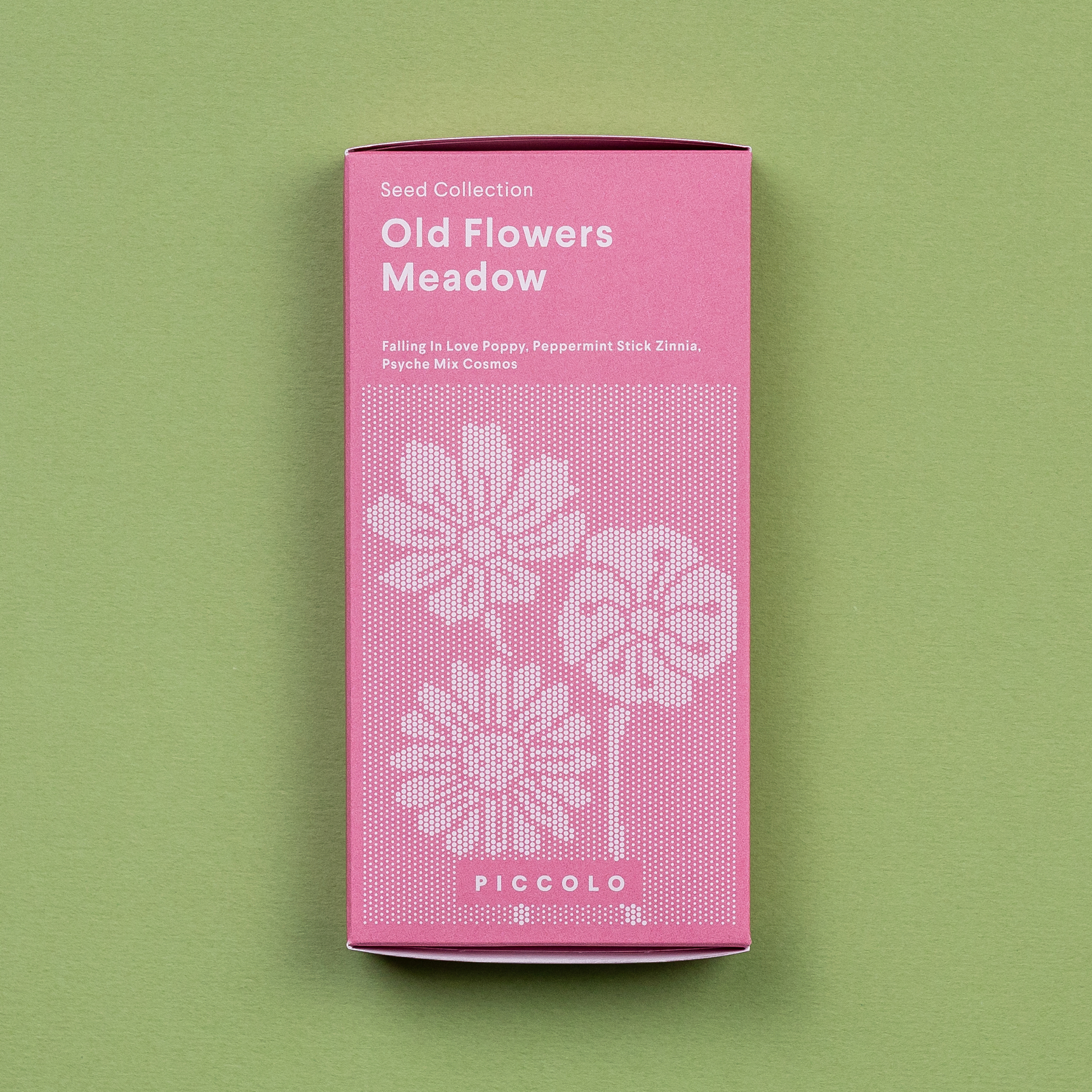 Das rosafarbene Päckchen Piccolo Seeds | Alte Blumenwiese von Piccolo Seeds zeigt Wildblumen-Illustrationen und listet auf der Vorderseite Falling in Love Poppy, Peppermint Stick Zinnia und Psyche Mix Cosmos vor einem grünen Hintergrund.
