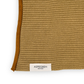 Eine Nahaufnahme eines beigen Strickstoffs mit braunem Rand, auf dessen Unterseite ein weißes Etikett mit der Aufschrift „Aspegren Denmark“ zu sehen ist. Dieses Handtuch aus Bio-Baumwolle ist Teil des „Aspegren Denmark | Küchentuch 3er-Geschenksets in Naturtönen“ – eine ideale, nachhaltige Ergänzung für Ihre Küchentextilien-Kollektion.