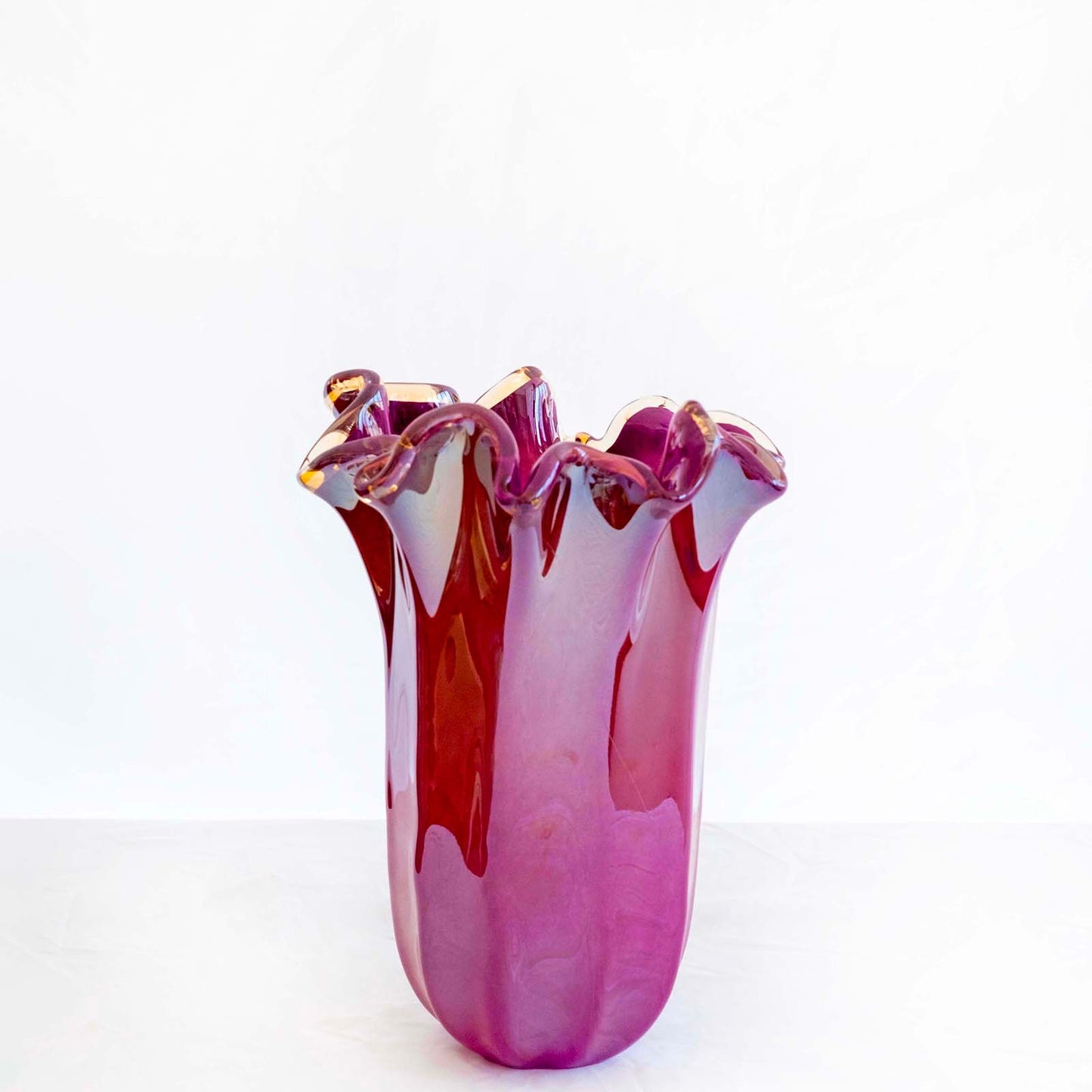 Eine große, violette „Fazzoletto“-Vase von Murano Dream (H 31, Ø 20 cm) mit wellenförmigem, ausgestelltem Rand und glänzendem Murano-Glas steht vor einem weißen Hintergrund.