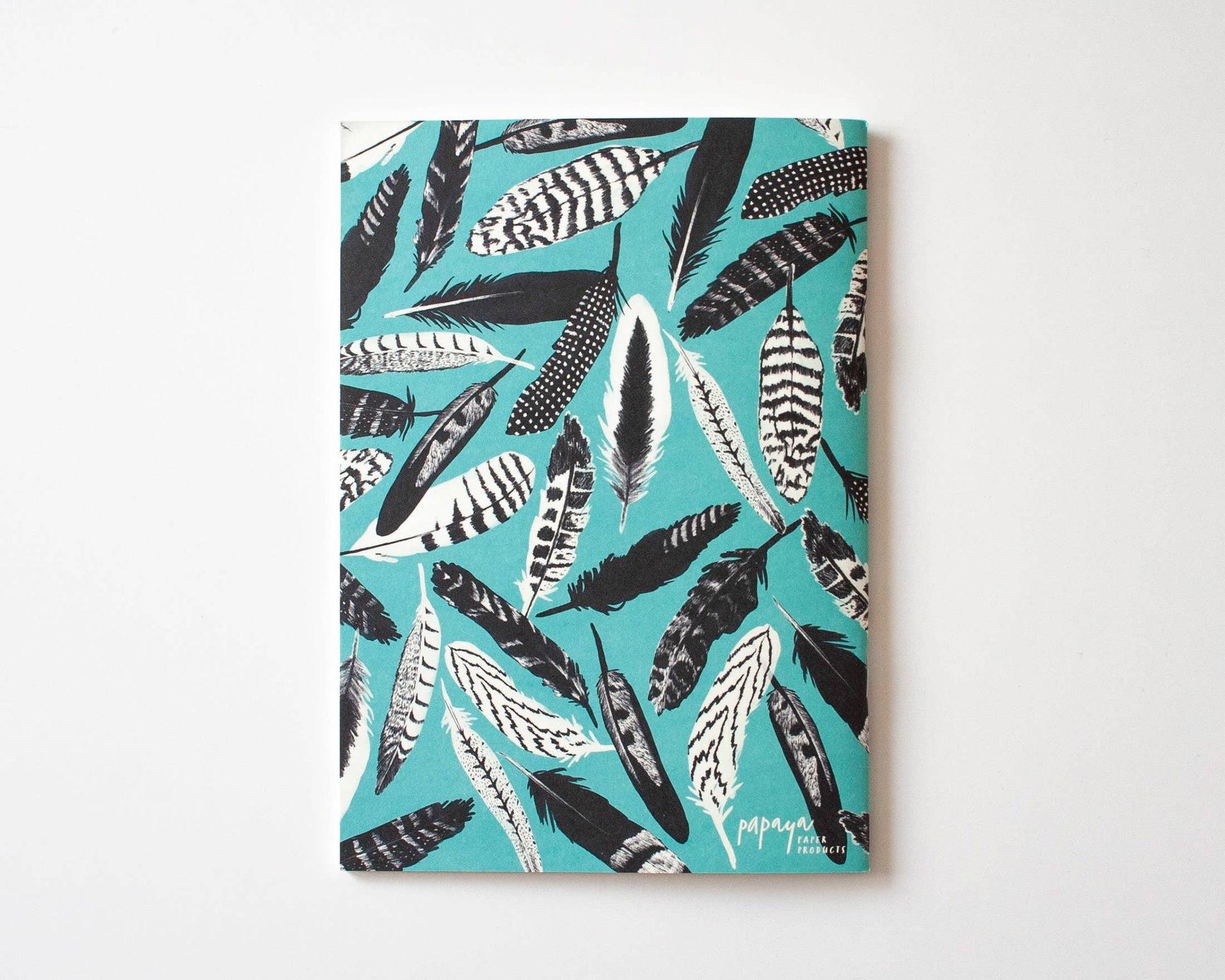 Das Notizheft A5 von Papaya Paper Products überzeugt mit einem blauen Federmuster-Cover in Schwarz, Weiß und Grau - nachhaltig produziert und ideal für stilvolles Schreiben.