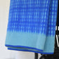 A Sofie Sjöström | 'Darling' blaue Tagesdecke aus Lammwolle von Sofie Sjöström Design mit Farbverlauf und Gittermuster liegt über einem dunklen Stuhl.