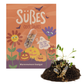 Eine farbenfrohe Verpackung, verziert mit Blumen, Kürbissen und deutschem Text, zeigt eine durchsichtige Kapsel, die Samen enthält. Im Vordergrund sind Erde mit keimenden Sämlingen und eine sichtbare Samenkapsel zu sehen. Das fröhliche Design steht ganz im Zeichen von Halloween und präsentiert das Saatgut „Süßes oder Saures“ von Stadtgärtner – die Halloween-Saatpille „Süßes“, eine Wildsamenmischung, die sich perfekt für Feierlichkeiten in Stadtgärten eignet.