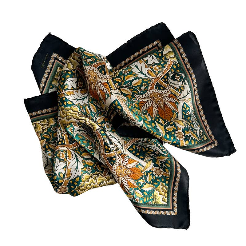 Der Koustrupco Seidenschal "Morris Windrush" (50 x 50 cm) zeigt ein florales Muster in Grün, Gold, Braun und Creme mit schwarzem Rand - inspiriert vom klassischen William Morris Design.