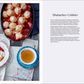 Eine Pfanne mit gebackenem Rhabarber Cobbler, einem britischen Klassiker, steht neben einem Teller mit Cobbler und Tee. Das Rezept aus "London Lovestory" vom Hölker Verlag ist auf der gegenüberliegenden Seite auf Deutsch abgebildet.