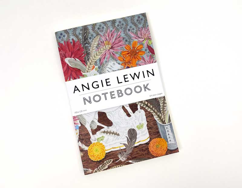 Das Art Angels Angie Lewin | Notizbuch 'Zebra, Dahlien und Federn' zeichnet sich durch ein farbenfrohes Cover mit Blumen und Federn aus, auf dem ein weißer Streifen den Namen der Künstlerin und den Titel des Notizbuchs zeigt.