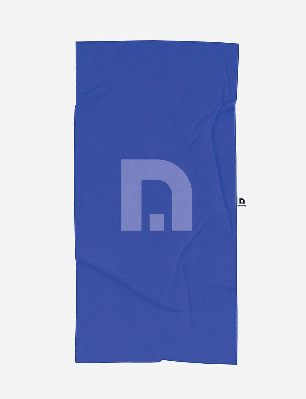Das Notabag-Handtuch mit roten und violetten Streifen (78 × 160 cm) von Notabag wird vor einem schlichten, hellen Hintergrund gezeigt – mit seinem auffälligen Muster, dem weichen Recyclingmaterial und einem kleinen schwarz-weißen Markenetikett am Rand.