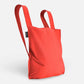 Der Notabag | „Original Red“ – Tasche und Rucksack in einem von Notabag – steht mit zwei Tragegriffen aufrecht und vereint die Funktionalität eines Rucksacks und einer Tragetasche in einer umweltfreundlichen, stilvollen Mehrwegtasche vor einem schlichten weißen Hintergrund.