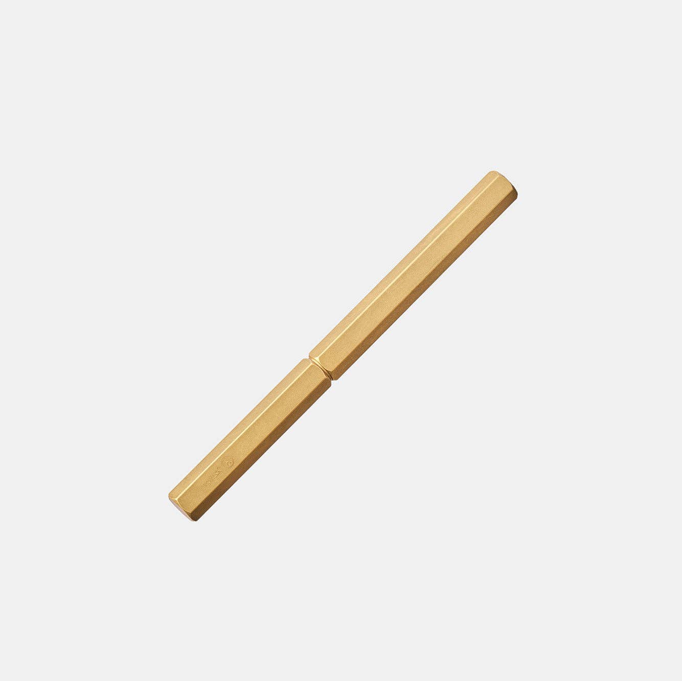 Der ENTREPÔT YSTUDIO Klassischer Revolve-Rollerball-Stift (Messing) zeichnet sich durch ein goldfarbenes, sechseckiges, minimalistisches Design mit einem stabilen Griff aus, der diagonal auf weißem Grund dargestellt ist.