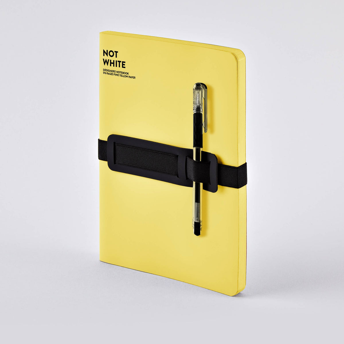 Ein nuuna „Not White Yellow“ L Light A5+ Notizbuch-Set mit Gelstift, bestehend aus einem gelben Notizbuch, das mit einem schwarzen Gummiband zusammengehalten wird, und einem schwarzen Gelstift, wird vor einem schlichten hellgrauen Hintergrund präsentiert.