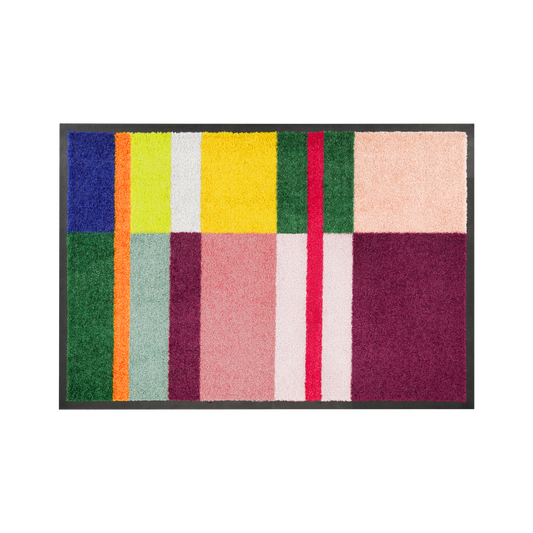 Die Remember Fußmatte 'Giorgio' ist waschbar, rutschfest und besticht durch ihr geometrisches Design aus bunten Rechtecken und Streifen in Grün, Blau, Gelb, Orange, Pink, Rot und Bordeaux sowie einem schwarzen Rand.
