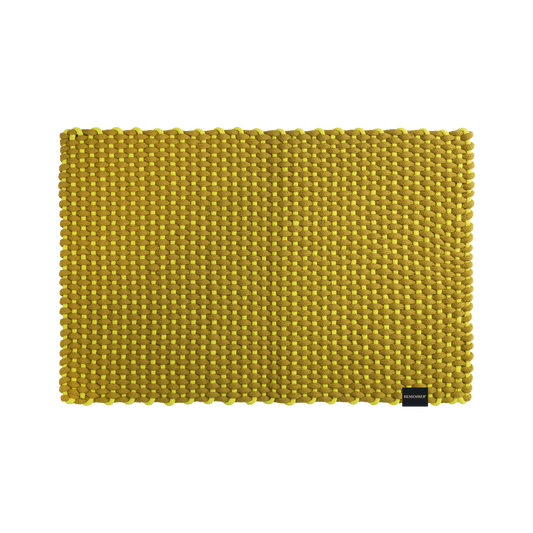 Die Fußmatte „Lida“ von Remember in der Farbe Limette (90 x 58 cm) ist eine rechteckige, gelb gewebte Matte mit einer groben Struktur, die aus einer Mischung aus Baumwolle und Polypropylen gefertigt ist. Diese handgewebte Fußmatte von Remember, die in der rechten unteren Ecke mit einem kleinen schwarzen Etikett versehen ist, eignet sich hervorragend als stilvolle Fußmatte für den Innenbereich und wird hier vor einem weißen Hintergrund gezeigt.