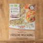 Eine Packung Sperli's | Bio Keimsprossen Saatgut 'Frische Mischung' ist auf Holz ausgestellt und zeigt frische Sprossen und Mahlzeiten. Die Verpackung hebt die Bio-Saatgut-Zertifizierung und eine schnelle Keimzeit hervor.