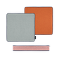 Zwei quadratische Remember Sitzkissen 'Peanut' (40 x 40 x 5 cm) in Hellgrau und Orange mit dunklem Rand sind nebeneinander abgebildet. Darunter befindet sich ein schmaler rosa Stoffbeutel mit Reißverschluss - alles auf weißem Hintergrund.