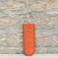 Ein hellbraunes Lederetui für Stifte oder Bleistifte mit sichtbaren Nähten und japanischen Schriftzeichen, das an die „Leather Sheath“ Lederschutzhülle für kleine Messer von Niwaki erinnert, steht aufrecht an einer strukturierten Steinwand.
