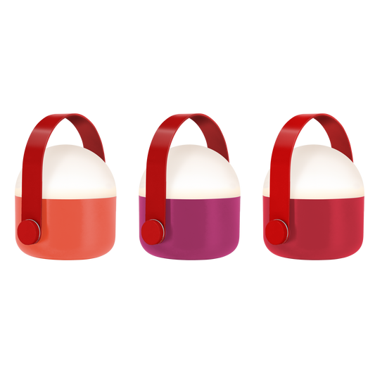 Hier ist eine überarbeitete Version Ihres Satzes unter Verwendung der bereitgestellten Produktdaten: Drei moderne, kuppelförmige tragbare Lampen von Remember – das „Ole mini LED Leuchten Rot 3er Set“ – verfügen über breite Griffe und dimmbare, batteriebetriebene Mini-LED-Leuchten. Jede Lampe hat eine weiße Oberseite und einen leuchtend orangefarbenen, violetten oder roten Sockel und wird vor einem schlichten weißen Hintergrund präsentiert.