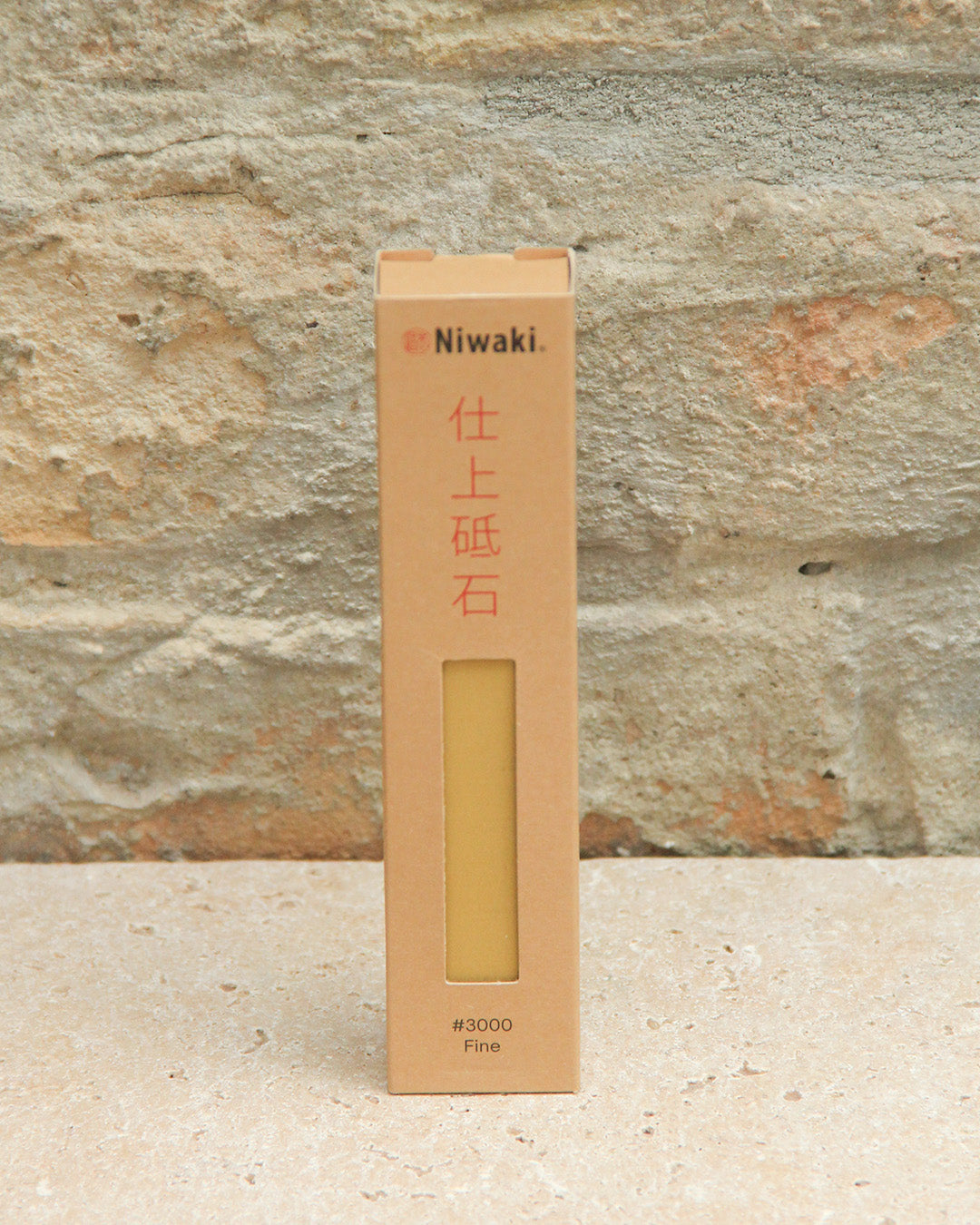Der Niwaki | 'Sharping Stone' Schleifstein fein steht aufrecht in einer beigen Ausschnittbox, beschriftet mit #3000 Fein - ideal zum Schärfen von Gartengeräten und geeignet für feine, mittlere oder grobe Schärfanforderungen.