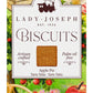 Entdecken Sie die „Apple Pie Biscuits“ von Lady Joseph – Apfel & Zimt – eine 100-g-Packung (3,5 oz) handgefertigter, palmölfreier, veganer Kekse. Die bezaubernde Verpackung zeigt Äpfel, einen Picknickkorb und eine malerische Landschaft. Genießen Sie den köstlichen Geschmack von Apfel und Zimt (Apfel-Zimt-Kekse) von Lady Joseph.