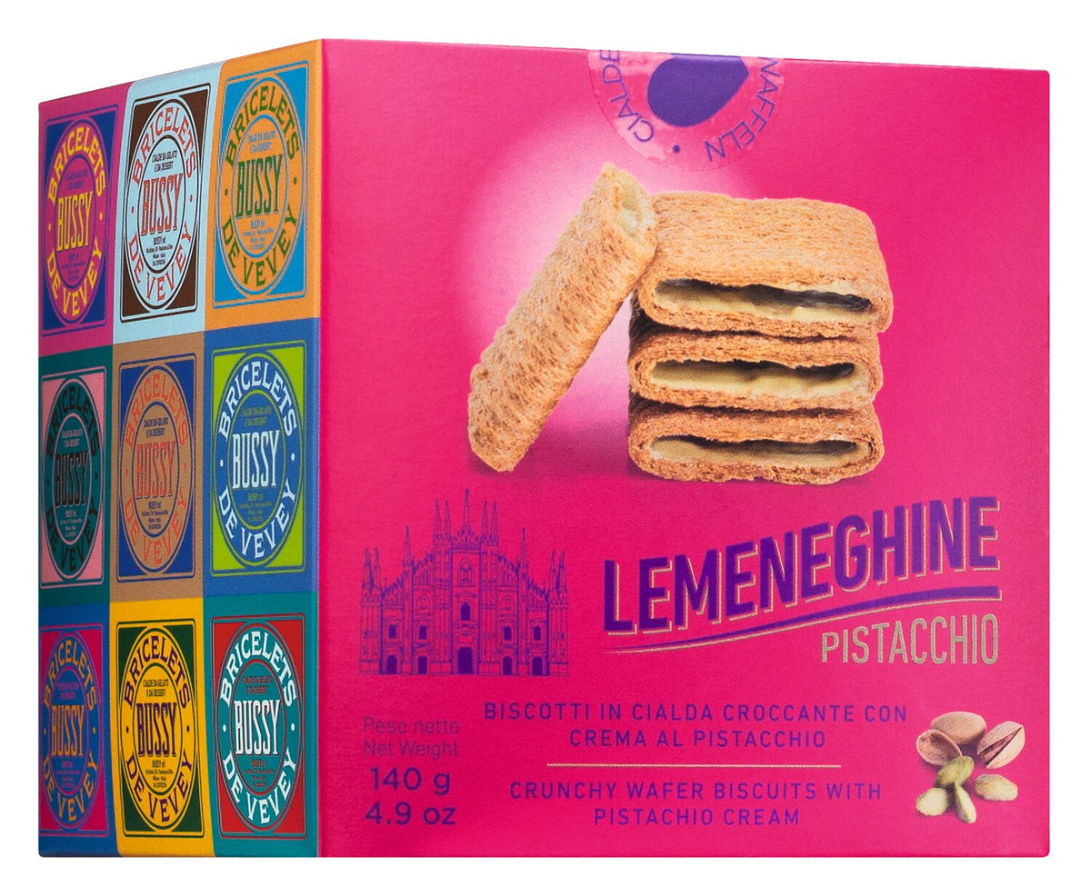 Eine rosa Schachtel „Bussy Le Meneghine“ | „Pistacchio“-Waffelgebäck 140 g von Bussy, mit drei Waffeln, Pistazien und auffälligen runden Logos an der Seite. Auf der Verpackung wird diese italienische Spezialität als knuspriges Waffelgebäck mit einer köstlichen Pistaziencreme-Füllung beschrieben.