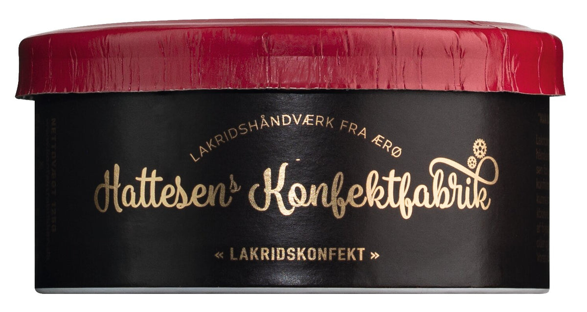 Eine schlichte, schwarz-rote Dose, verziert mit goldener Schrift und eleganten Details, zeigt das Markenlogo von „Hattesens Lakritzkonfekt“ sowie dänische Schriftzüge, darunter „Lakridshåndværk fra Ærø“ auf der Vorderseite, und bietet eine köstliche Auswahl an Lakritzkonfekt in einzigartigen Geschmacksrichtungen wie Blau-, Stachel- und Erdbeere.