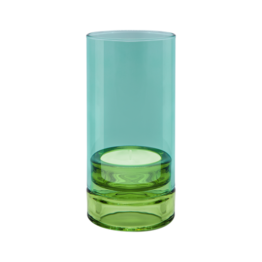 Das „Remember | Windlicht ‚Lys’ Sky“ von Remember ist ein zylindrisches Windlicht aus Glas, dessen obere Hälfte in transparentem Aquablau gehalten ist und dessen Sockel aus durchgefärbtem Grün besteht – elegant in Szene gesetzt vor einem weißen Hintergrund.