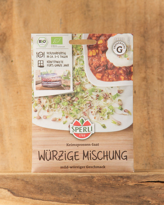 Die Bio Keimsprossen Saatgut 'Würzige Mischung' von Sperli sind bio-zertifiziert und haben einen mild-würzigen Geschmack. Die Verpackung zeigt Keimsprossen, die auf Brot und Salat serviert werden.