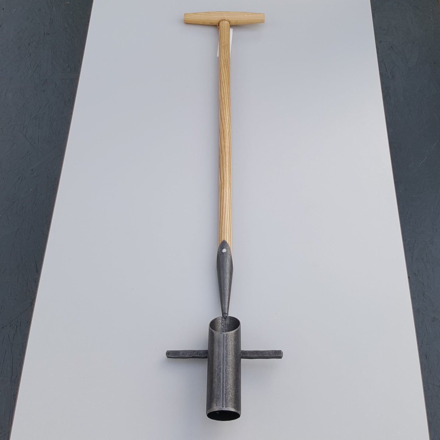 Der Krumpholz | Zwiebelpflanzer 1349 mit Eschen-T-Stiel und metallener Zylinderspitze von Krumpholz liegt auf einer grauen Fläche.